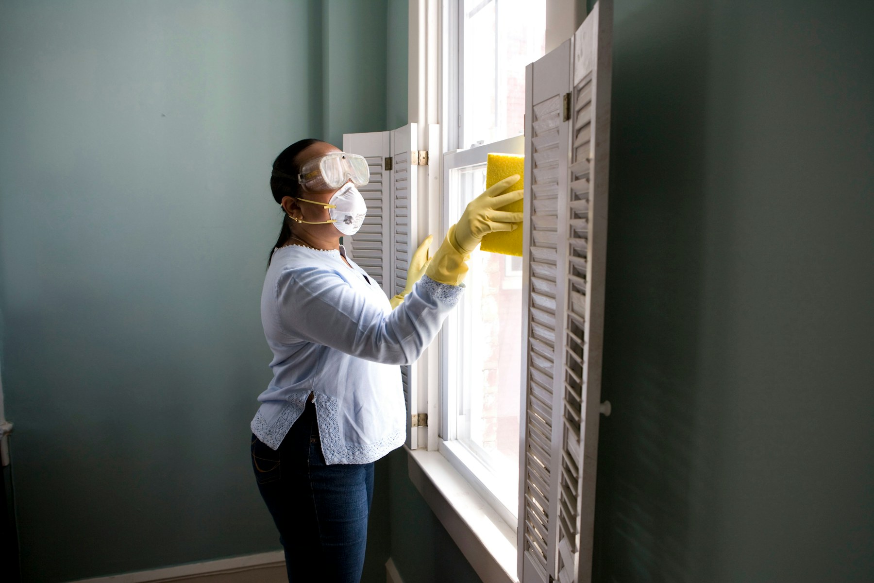 A home maintenance professional fitting hardware in a kitchen